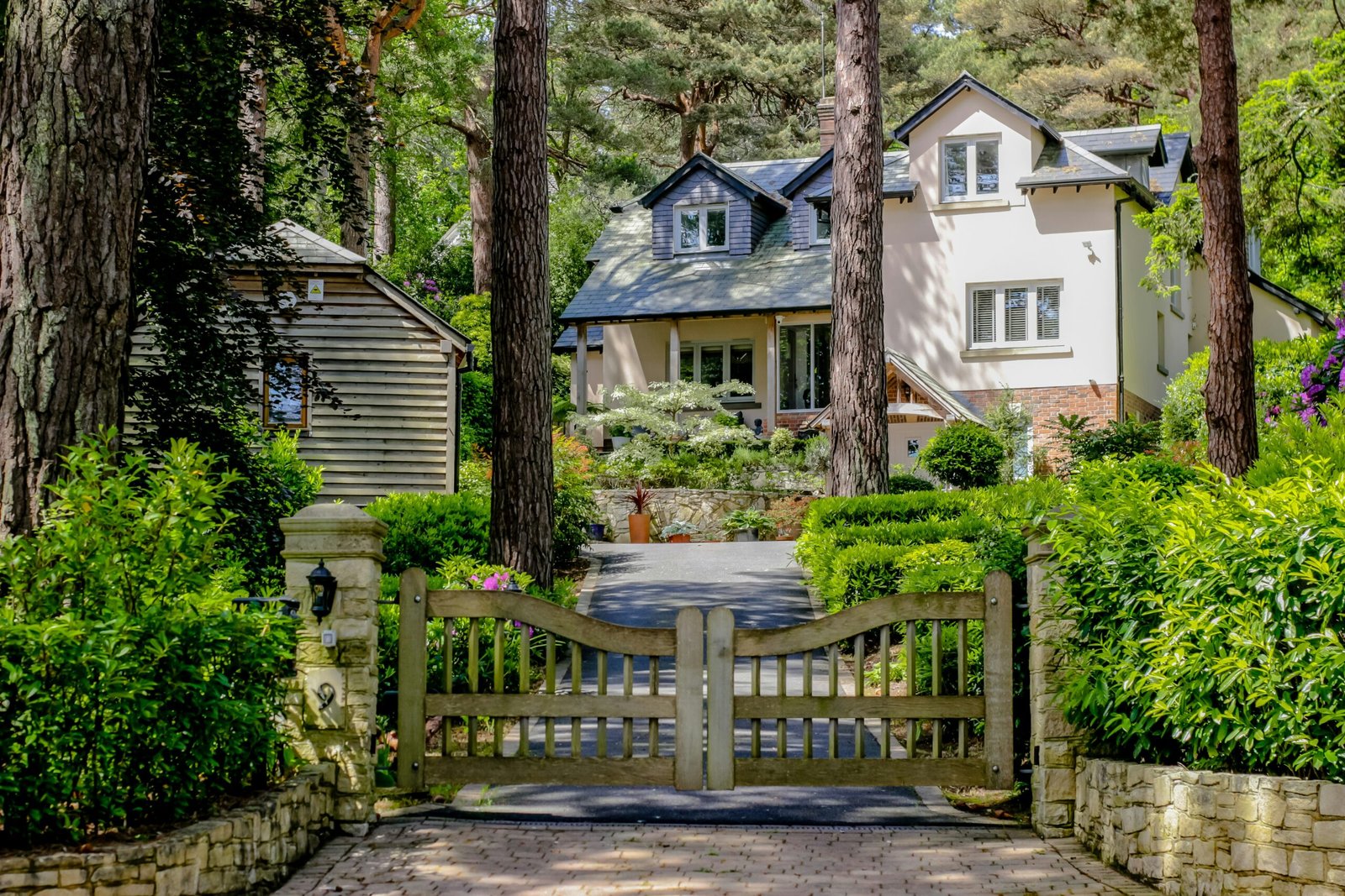 A driveway with a gate leading to a house